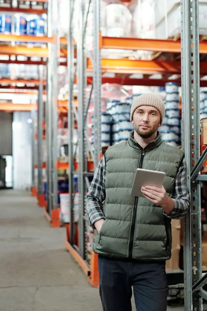 Trabajador de bodega con una tableta revisando inventario
