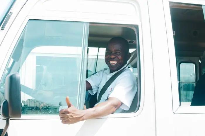 Conductor sonriendo al volante de un vehículo